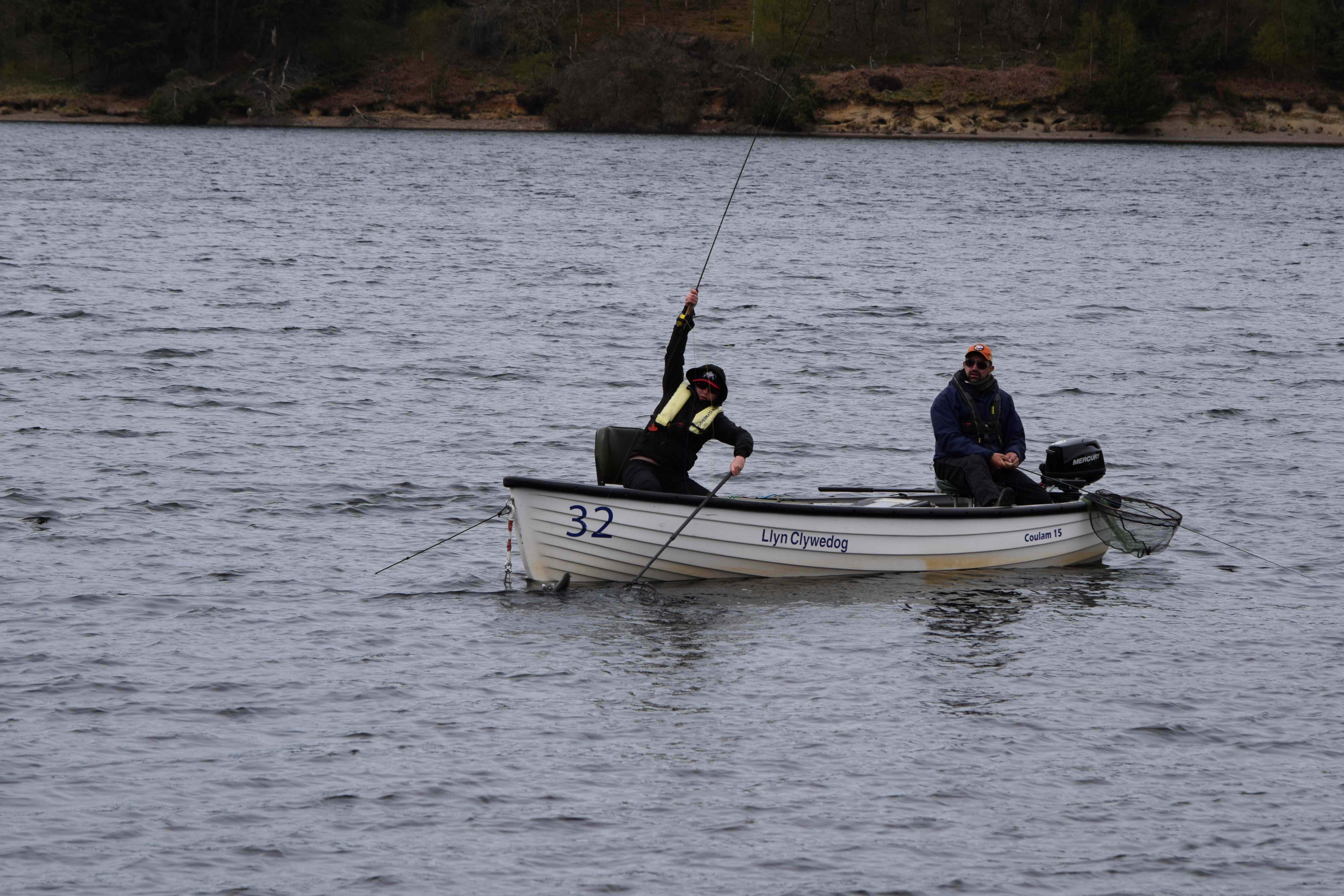 Youth team member landing a Trout from a boat